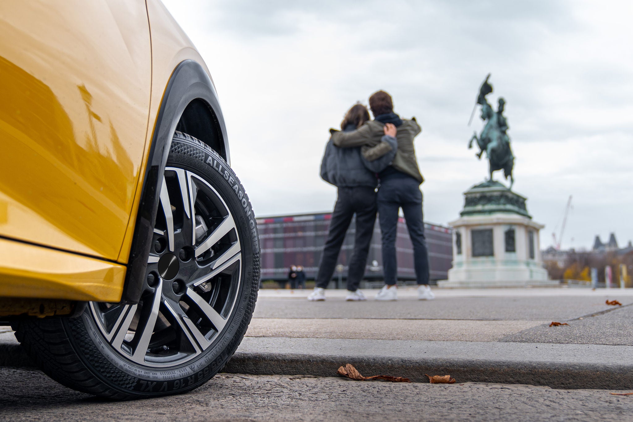 Fahrzeug mit Semperit AllSeason-Grip 2 Reifen, dahinter 2 Personen