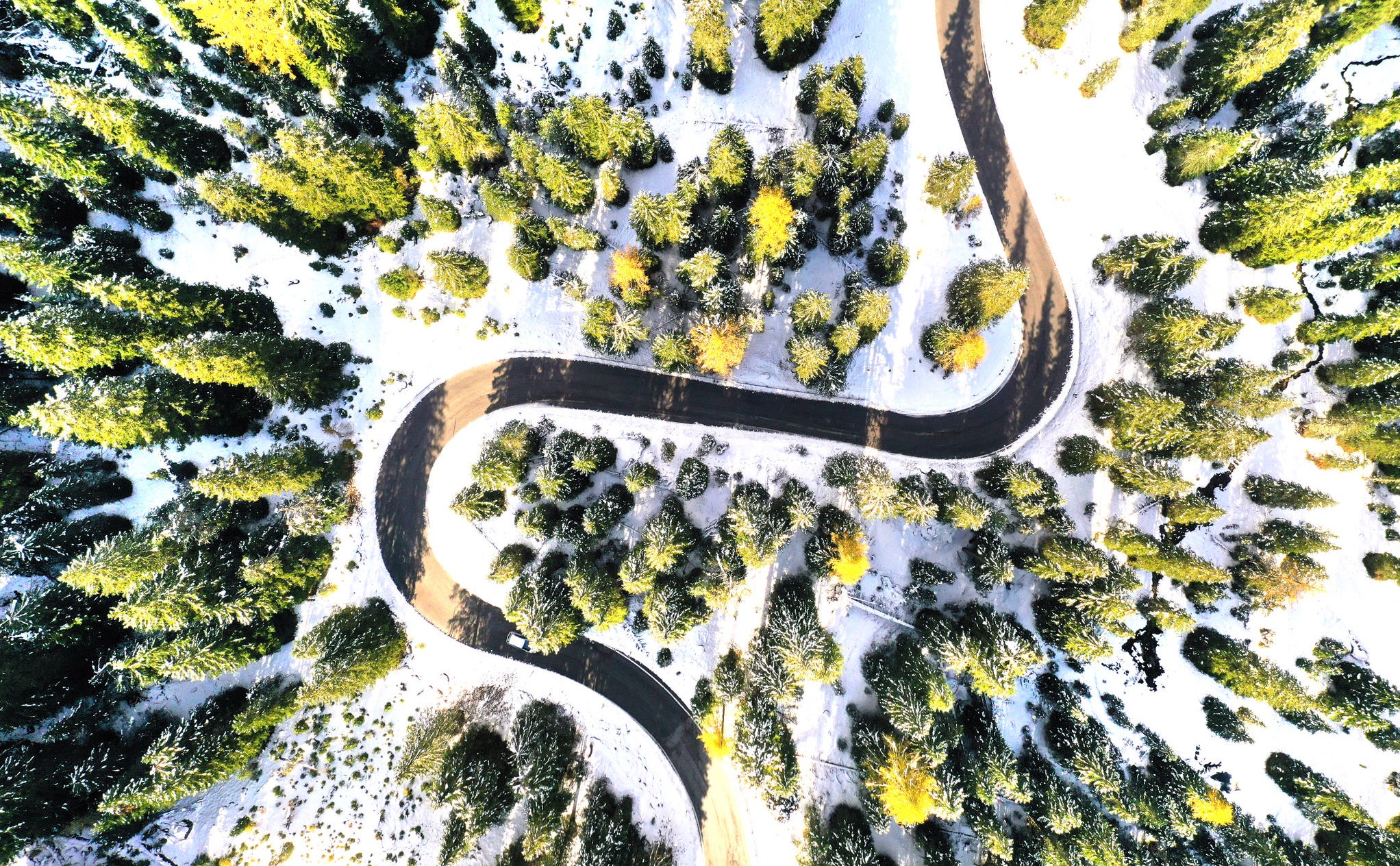 Aerial drone view of windy road during winter Blue Van in Snow