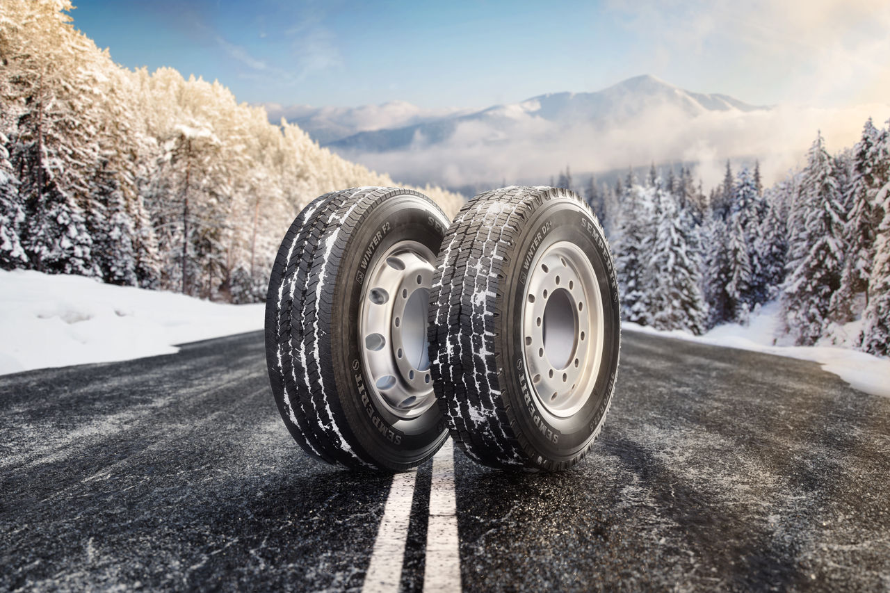Semperit WINTER F2 and WINTER d2+ keyvisual Straight Mountain Road in winter with two Tyres in the Front 