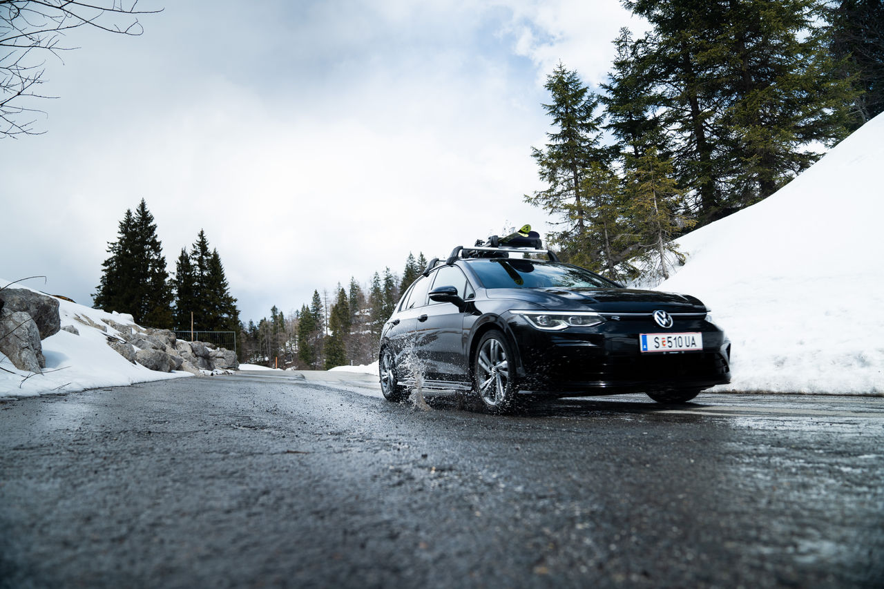 Car driving up the hill in winter on wet road