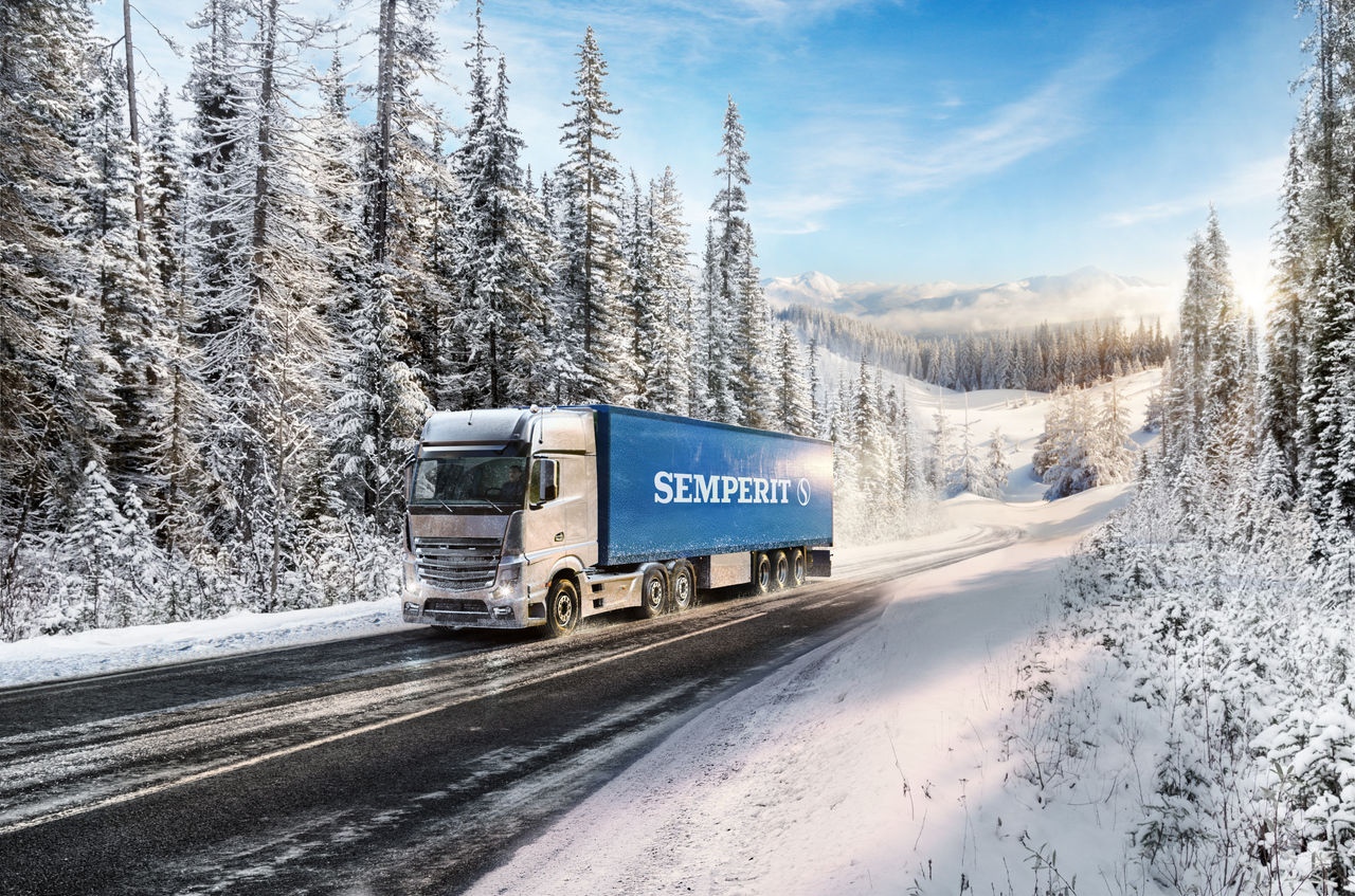 Semperit 3 Axle-Truck Truck driving up the hill in winter on regional road