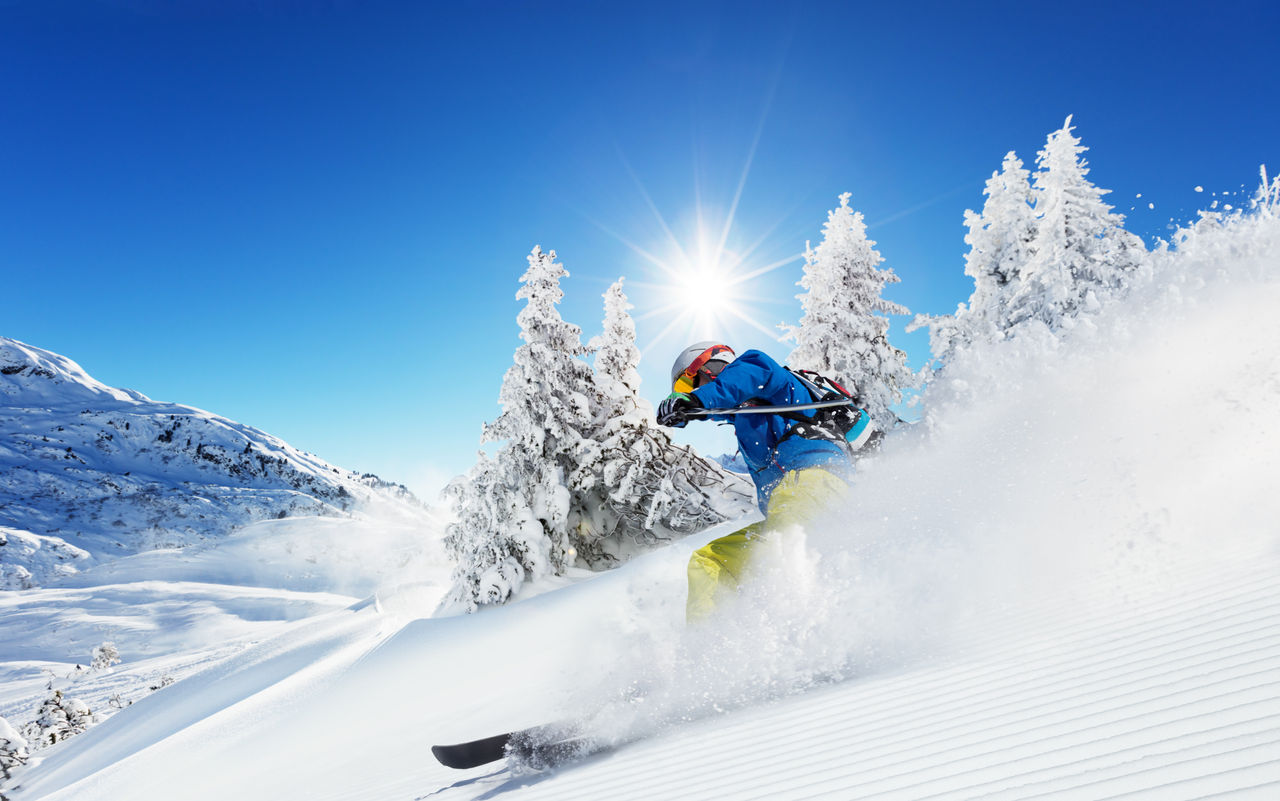 Man skier running downhill on sunny Alps slope