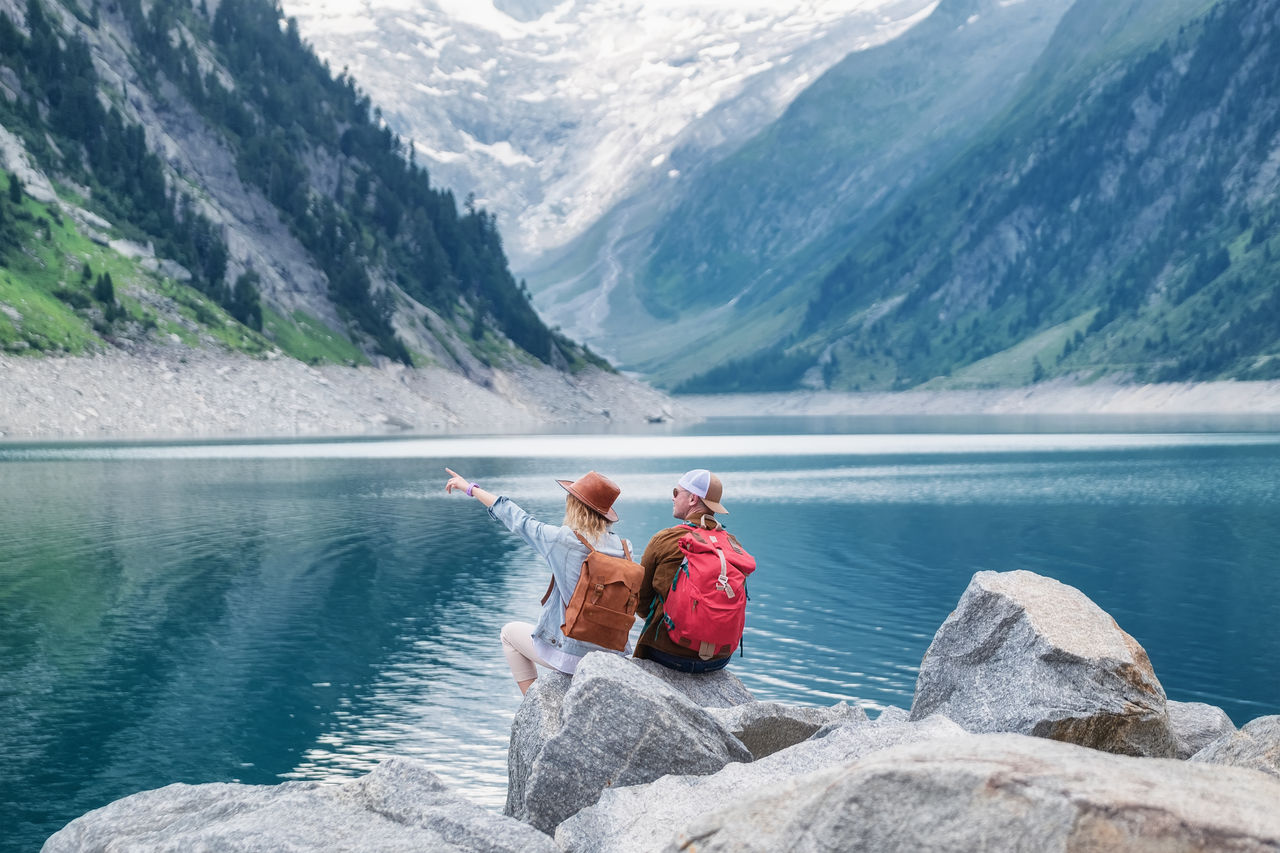 Travel image. Travelers team look on the mountain landscape. Travel and active life concept with team. Adventure and travel in the mountains region in the Austria